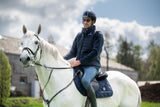Jeździec w kasku KEP na siwym koniu z czaprakiem Prestige Italia – kim jest saddle fitter i czym się zajmuje, poradnik Equishop