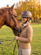 Rider wearing a brown Samshield Miss Shield 2.0 Crystal Fabric Gold helmet with her horse in an autumn paddock (AI)