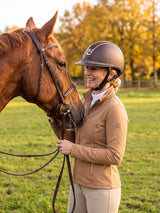 Rider wearing a brown Samshield Miss Shield 2.0 Crystal Fabric Gold helmet with her horse in an autumn paddock