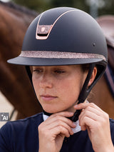 Rider fastening a Samshield Miss Shield 2.0 Rose Gold helmet (AI)