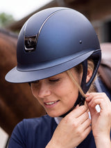 Rider fastening a navy Samshield Miss Shield 2.0 Black Chrome helmet