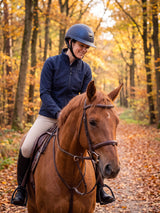Rider wearing a navy Samshield Miss Shield 2.0 Black Chrome helmet on an autumn hack in the forest