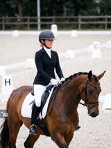 Rider wearing a Samshield Miss Shield 2.0 Royal Tiara helmet during a dressage test (AI)