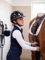 Rider wearing a Samshield Miss Shield 2.0 Shadowglossy Night Shade helmet loosening the girth after training (AI)