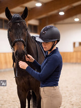 Rider wearing a Samshield Miss Shield 2.0 Shiny Crystal Fabric helmet with her horse in the indoor arena (AI)