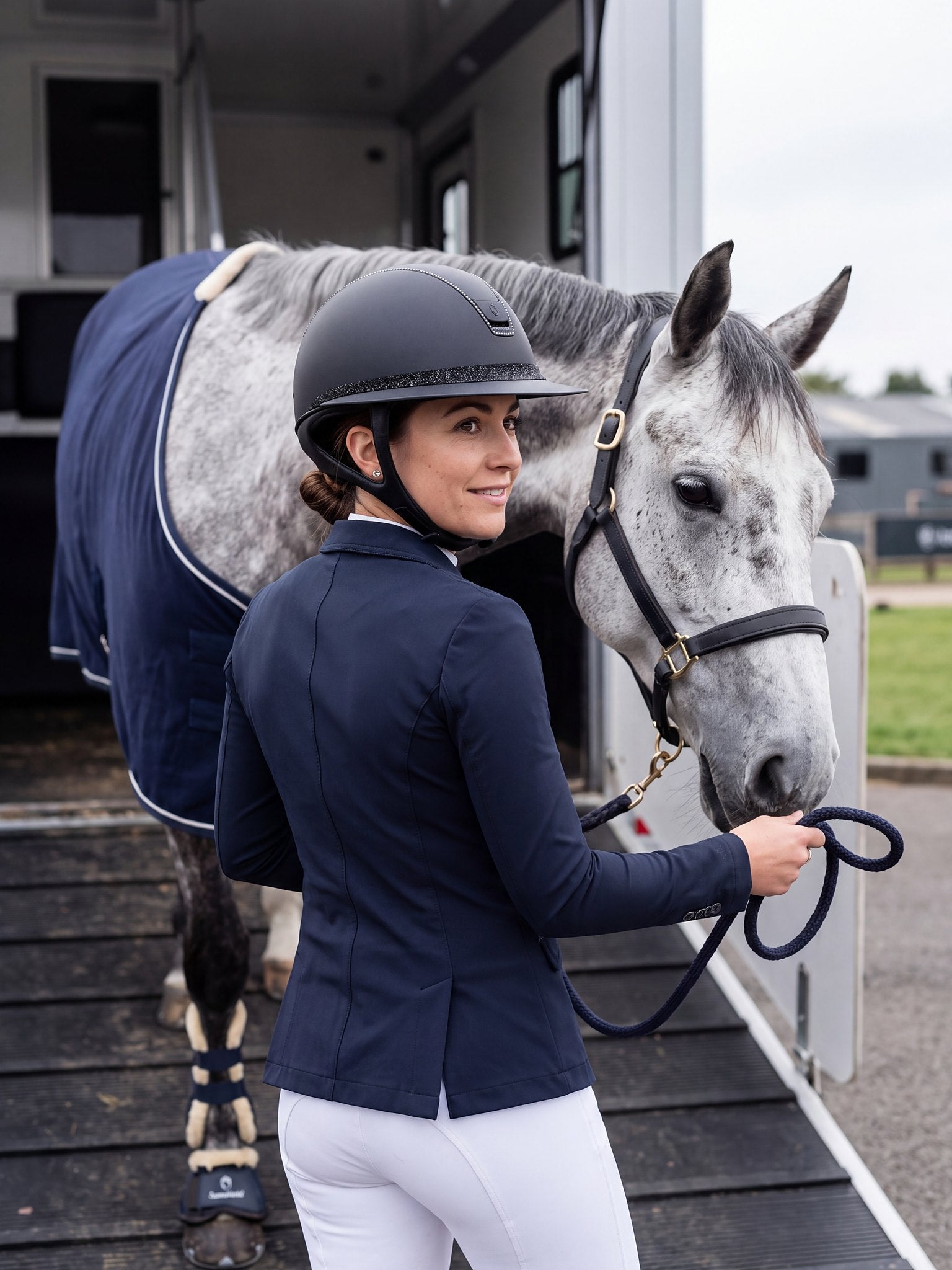 Rider wearing a Samshield Miss Shield 2.0 Sparkling 300 Swaro helmet leading her horse down the horse lorry ramp