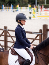 Rider wearing a Samshield Miss Shield 2.0 Sparkling Ultra Fine Rock helmet waiting at the in-gate of the show-jumping arena (AI)
